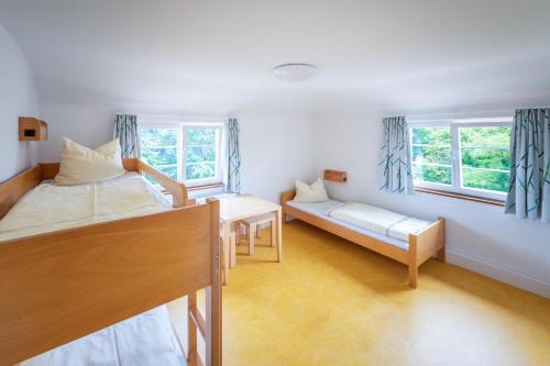 a bedroom with two beds and a couch and two windows at Jugendherberge Schwäbisch Hall in Schwäbisch Hall