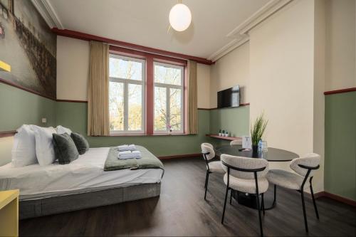 a bedroom with a bed and a table and chairs at The Queen's Twelve by Romy&Travis in Bruges