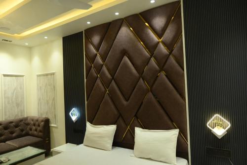 a bedroom with a bed and a brown headboard at Hotel Tim Hartins in Hisār