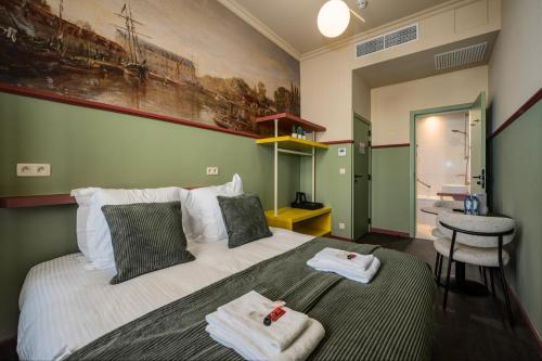 a bedroom with a large bed with towels on it at The Queen's Twelve by Romy&Travis in Bruges
