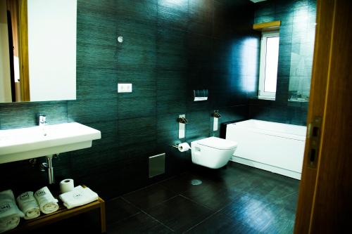 a black bathroom with a toilet and a sink at Villa Prime Hotel in Vila Nova de Famalicão