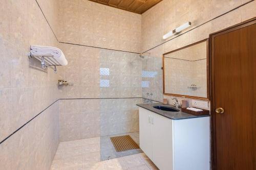 une salle de bain avec un lavabo et un miroir dans l'établissement Lions Den Estate 7 BD Ramgarh serviced Villa BBQ, à Rāmgarh
