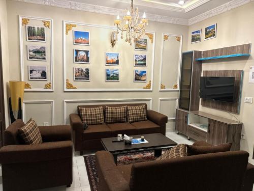 un salon avec un canapé et une télévision dans l'établissement Backpackers Den, à Lahore