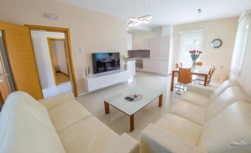 a living room with a white couch and a table at Holiday Home The Olive Escape in Stolac