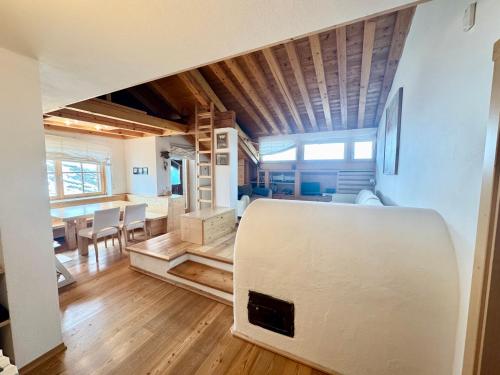 a living room and dining room with a white refrigerator at Esperienza Unica al Passo Giau - Appartamento con Vista Panoramica in Colle Santa Lucia