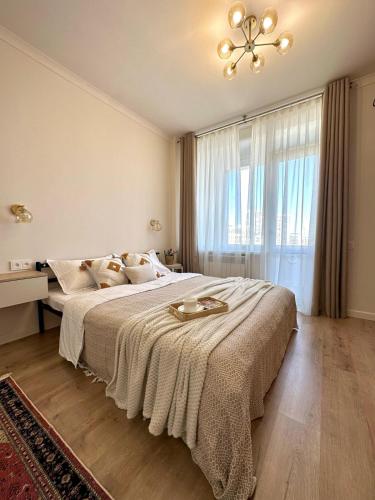 a bedroom with a large bed with a large window at Apartment with a Barys projector in Gornyy Gigant