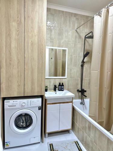 a bathroom with a washing machine and a sink at Apartment with a Barys projector in Gornyy Gigant