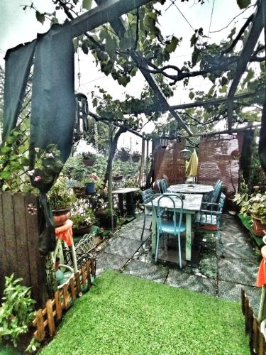 a garden with a table and chairs on a patio at Art B&B La Casa del Pittore in Revine Lago