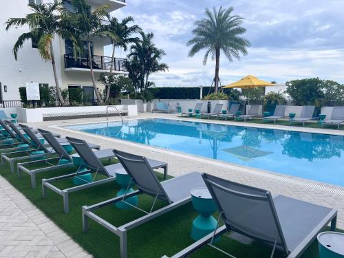 a pool with chairs and a table and a building at The Art House Little Havana in Miami