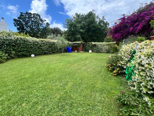 a yard with flowers and a blue ball at Casa de la Luna in Nettuno