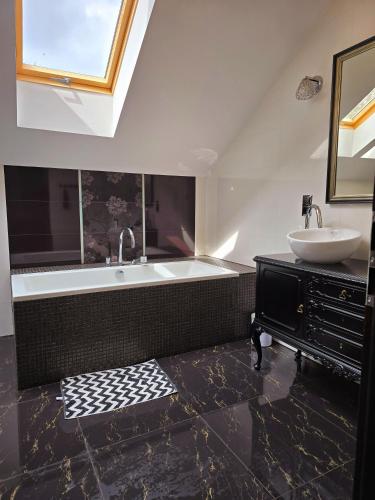 a bathroom with a sink and a bath tub at Apartamenty Boszkowo Wczasowa in Boszkowo