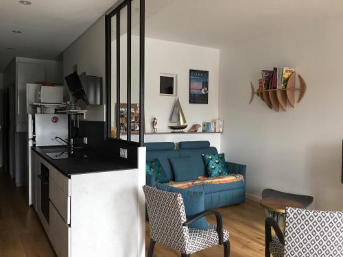 un salon avec un canapé bleu et une cuisine dans l'établissement vue Port, à Pornic