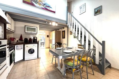 une cuisine avec une table et des chaises ainsi qu'un escalier dans l'établissement Le Hameau - Proche plage - Piscine - Parking, à Saint-Cyprien