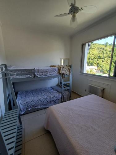 a bedroom with two bunk beds and a window at VISTA DESLUMBRANTE APTO 709 in Ubatuba