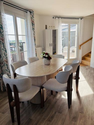 une salle à manger avec une table et des chaises dans l'établissement Duplex spacieux, au Blanc-Mesnil