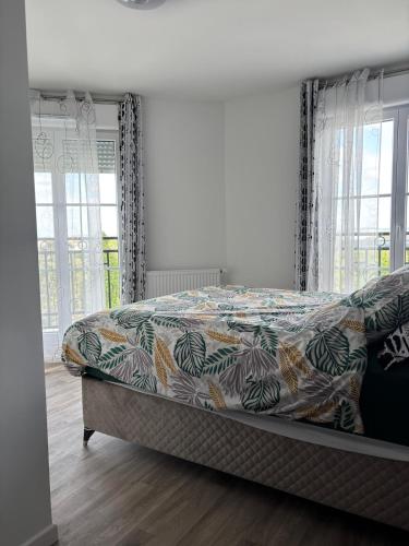- une chambre avec un lit doté d'un couvre-lit coloré dans l'établissement Duplex spacieux, au Blanc-Mesnil