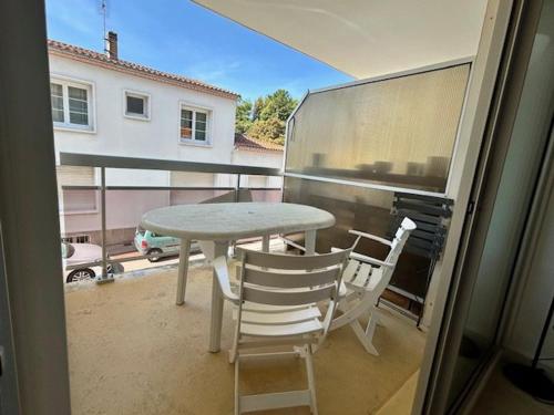 d'une table et de chaises sur un balcon avec vue sur une voiture. dans l'établissement Appartement T2 à Royan, 4 pers., proche plage et commerces, parking, balcon, confortable et équipé - FR-1-494-60, à Royan