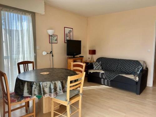 a living room with a table and a couch at Appartement 3 pièces proche de la plage avec parking - FR-1-494-146 in Royan