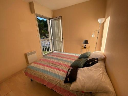 une chambre avec un lit avec une grande fenêtre dans l'établissement Appartement 3 pièces proche de la plage avec parking - FR-1-494-146, à Royan