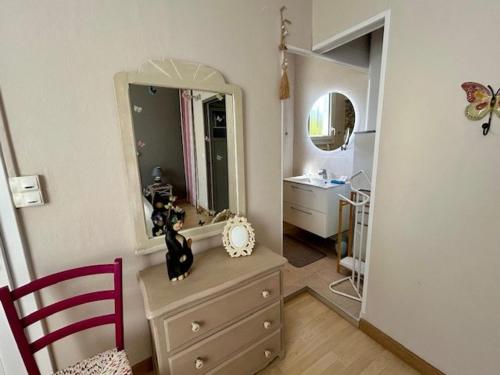 La salle de bains est pourvue d'une commode et d'un miroir. dans l'établissement Villa 1926 à Royan/Pontaillac, proche plage et commerces, 3 ch, parking privé, cuisine équipée. - FR-1-494-147, à Royan