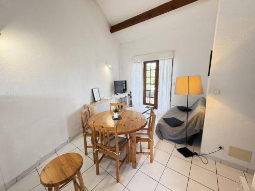 un salon avec une table et des chaises et un lit dans l'établissement Maison de plain-pied avec Wi-Fi, proche mer - FR-1-831-10, à Biscarrosse
