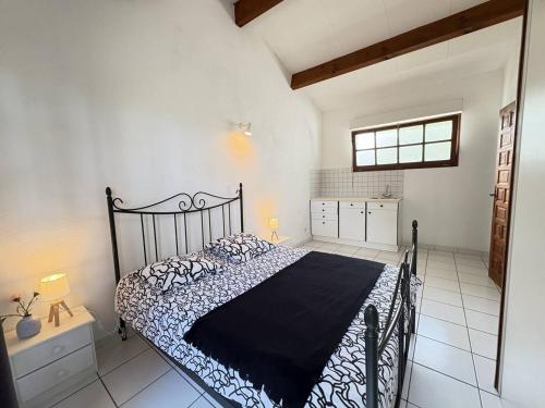 une chambre avec un lit avec une couette noire et blanche dans l'établissement Maison de plain-pied avec Wi-Fi, proche mer - FR-1-831-10, à Biscarrosse