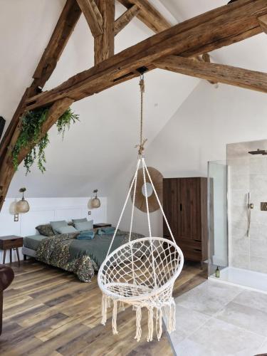 une chambre avec une balançoire dans une chambre avec un lit dans l'établissement La parenthèse-Logement cosy et Luxueux, à Veuzain-sur-Loire