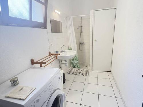 une salle de bain avec une machine à laver et un lavabo dans l'établissement Maison de plain-pied avec Wi-Fi, proche mer - FR-1-831-10, à Biscarrosse