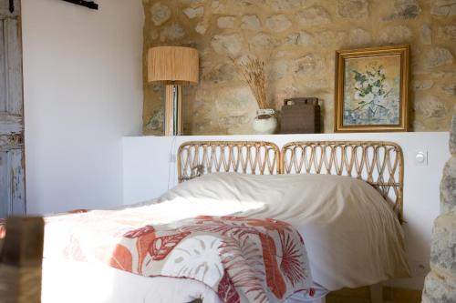 un lit dans une chambre avec un mur en pierre dans l'établissement La lussanaise, à Lussan