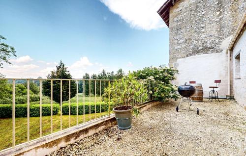 a garden with a fence and a grill at Lovely Home In Les Leves Et Thoumeyra in Les Lèves-et-Thoumeyragues