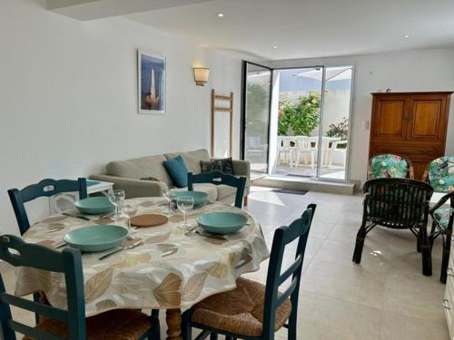une salle à manger avec une table et un salon dans l'établissement Appartement avec terrasse, 2 chambres, proche plage - 4 pers - FR-1-494-198, à Royan