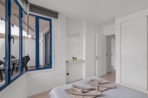 a bedroom with white walls and blue windows at Apartment Taurito big terrace in Taurito