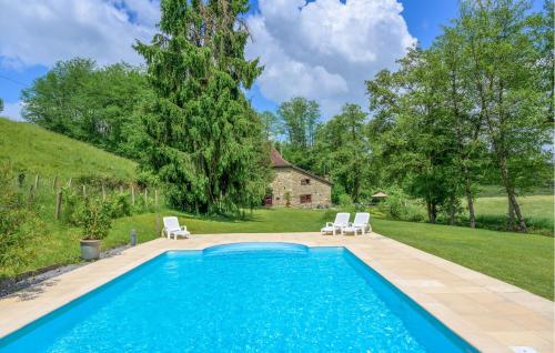 a swimming pool in a yard with two chairs and a house at Awesome Home In Lohitzun-Oyhercq in Lohitzun-Oyhercq