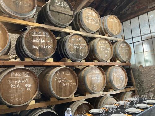 - un tas de tonneaux de vin empilés dans une pièce dans l'établissement Maison rénovée attenante à notre chai d'armagnac, à Vic-Fezensac