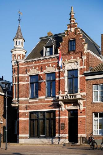 Sint-OedenrodeにあるPetite EnSuiteの時計塔のある赤レンガ造り