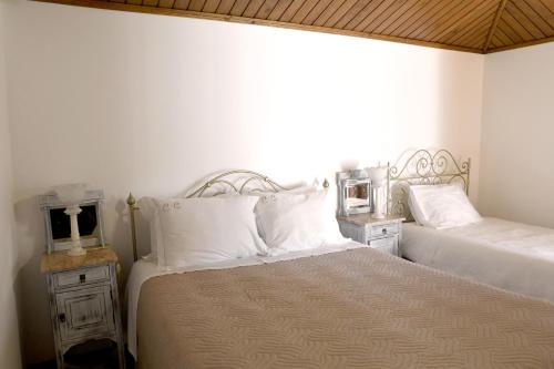 ein Schlafzimmer mit zwei Betten und weißen Kissen in der Unterkunft Casa Do Carvalho in Viatodos