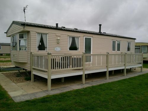 a mobile home with a porch and a deck at Eastgate Richmond 8 Berth Blow Heated Free WIFI in Ingoldmells