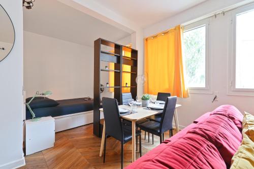 un salon avec une table et des chaises et un lit dans l'établissement Heart of Paris-Studio-Hotel des Invalides Netflix, à Paris