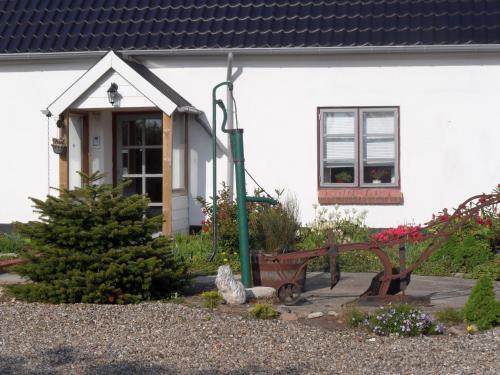 a white house with a bench and a christmas tree at Motel Herning in Kibæk