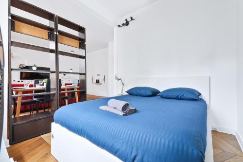 - une chambre avec un lit doté de draps bleus et d'oreillers bleus dans l'établissement Heart of Paris-Studio-Hotel des Invalides Netflix, à Paris