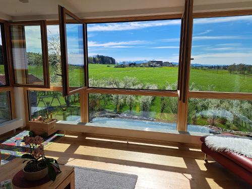 a room with large windows looking out at a golf course at Ferienwohnung Auf Dem Haldershof in Wangen im Allgäu