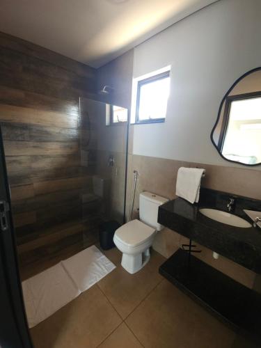 a bathroom with a toilet and a sink and a shower at Pousada Vila Caminito in Brotas