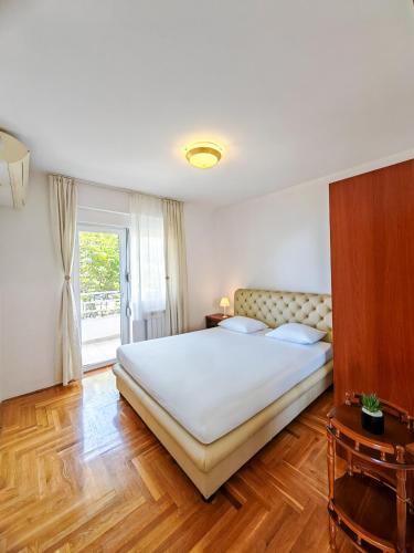 a bedroom with a large bed and a window at The rising sun-Stylish Sea View Apartment in Budva