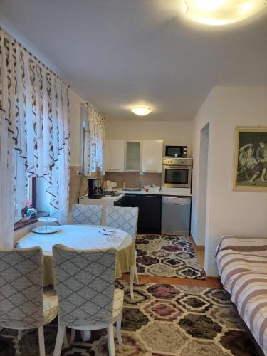 a kitchen and living room with a table and chairs at Star in Mali Lošinj
