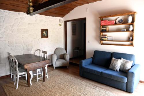 a living room with a blue couch and a table at Casa Do Carvalho in Viatodos