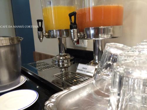 a kitchen counter with a mixer and some drinks at Assi Palace Hotel in Mirassol