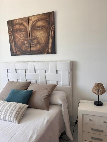 a bedroom with a bed with a painting on the wall at A Loureira in Portonovo