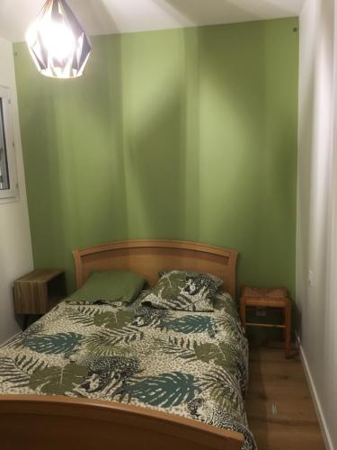 une chambre avec un lit et un mur végétal dans l'établissement vue Port, à Pornic