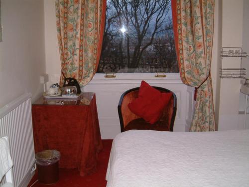 a bedroom with a bed and a window with a red pillow at Terrace hotel in Edinburgh