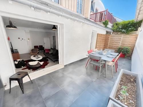 un patio avec une table et des chaises sur un balcon dans l'établissement Appartement les Marinières, à Deauville